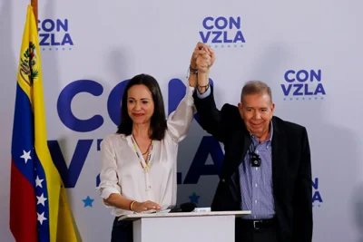 Opposition presidential candidate Edmundo Gonzalez, right, and opposition leader Maria Corina Machado join hands during a press conference in Caracas on Monday.