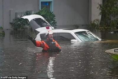 First responders in the water outside an apartment complex that was flooded from and overflowing creek due to Hurricane Milton in Clearwater, Florida