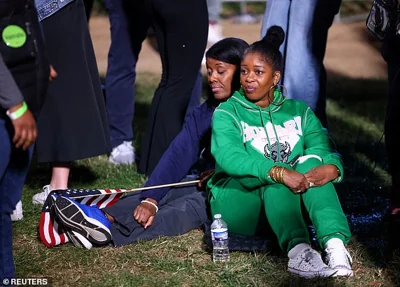 Supporters of Vice President Kamala Harris sit down in Howard University's quad and watch as election results point to a potential Donald Trump win