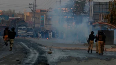 Police officers chase angry protestors in Peshawar, Pakistan, Tuesday, Nov. 19, 2024.