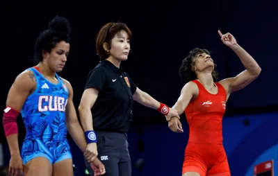 Vinesh Phogat of India (right) celebrates winning her semi-final bout. She would later be disqualified for failing to make weight ahead of her gold medal fight