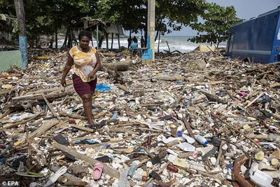 DOMINICAN REPUBLIC: A woman walks along the beach of Manresa, covered with garbage after the passage of Hurricane Beryl