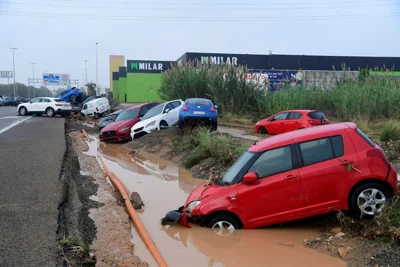 Cars have been left piled up after being swept away by the flood waters