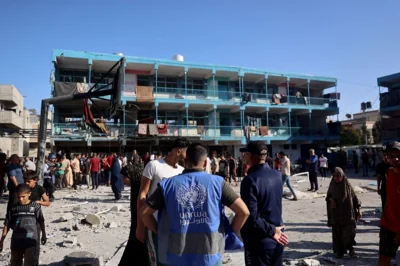 A member of the United Nations Relief and Works Agency for Palestine Refugees (UNRWA) checks the courtyard of the Al-Jawni (Jaouni) school after an Israeli air strike hit the site, in Nuseirat in the central Gaza Strip on September 11, 2024, amid the ongoing war in the Palestinian territory between Israel and Hamas. An Israeli air strike on September 11 hit a central Gaza school, with the Hamas-run territory's civil defence agency reporting 10 killed in the facility turned displacement shelter and the military saying it had targeted militants. (Photo by Eyad BABA / AFP)