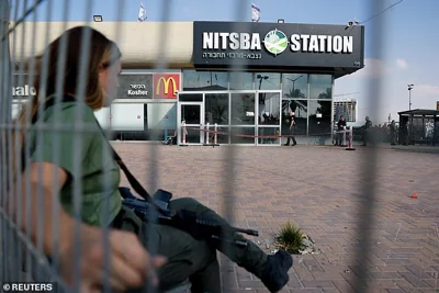 An Israeli Border Police officer sits near the scene of an attack in Beersheba, southern Israel, October 6