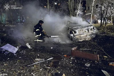 Ukrainian rescuers working at the site of a rocket hit on a residential building in Sumy