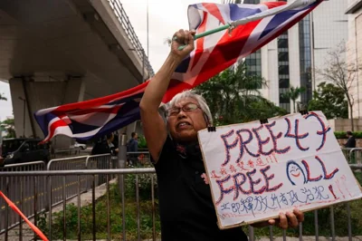 A pro-democracy activist known as 'Grandma Wong' protests outside the West Kowloon courts in a cordoned off area set up by police as closing arguments open in Hong Kong's largest national security trial of 47 pro-democracy figures, Hong Kong, Nov. 29, 2023. AP-Yonhap