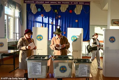 People place their ballot as they vote in the presidential elections and a referendum on joining the European Union