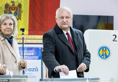 Former President of Moldova and Head of Socialist Party Igor Dodon (R) with his wife Galina (L) prepare to cast their ballots at a poling station in Chisinau