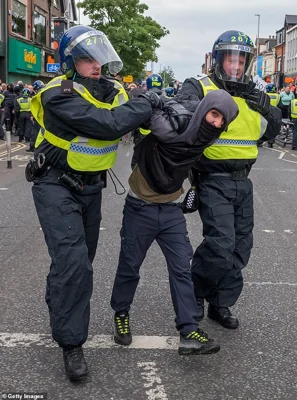 A man is detained by police officers as far-Right activists hold a demonstration in Middlesbrough
