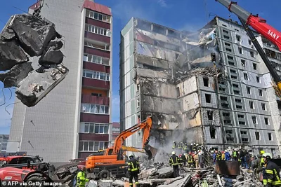 Rescuers search for survivors in the rubble next to damaged residential buildings in Uman, south of Kyiv, following Russian missile strikes