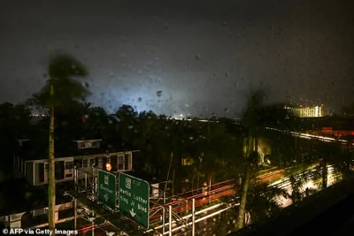 A power transformer explodes, creating a light in the background, as Hurricane Milton makes landfall in Fort Myers, Florida