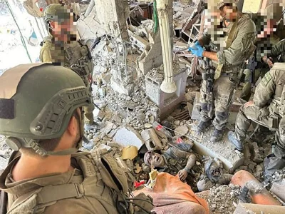 Israeli soldiers look down at the body of Hamas leader Yahya Sinwar in the rubble of his final refuge in Rafah