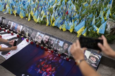 Photos of Ukrainian POWs killed in the explosions at the Russian-controlled barracks in Olenivka are placed around a memorial in Kyiv, 29 July 2023