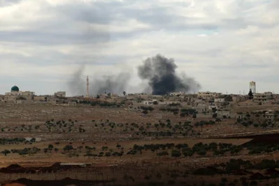 Smoke rises in the distance, above a residential landscape in Syria.