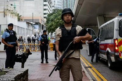 Armed police stand guard as a prison van arrives at the West Kowloon Magistrates' Courts building