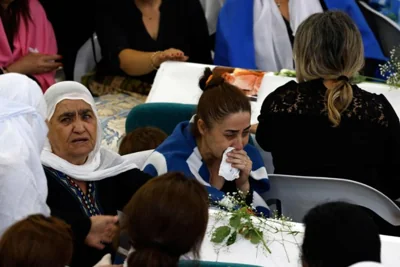 Druze women mourn near the coffins of loved ones after a reported strike from Lebanon fell in Majdal Shams village in the Israeli-annexed Golan area, July 28. Israel's military said Hezbollah fired the rocket from Lebanon, hitting a football pitch in the Druze town of Majdal Shams and killing the youngsters, who were between 10 and 20 years old. Another 18 youths were wounded in the attack, said the emergency services. AFP-Yonhap