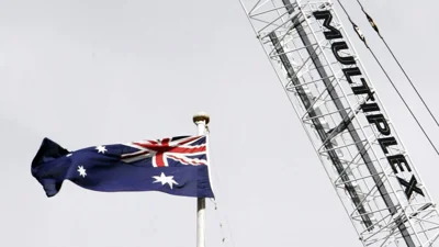 The Australian flag flutters below a Multiplex crane at a building site in Sydney, Tuesday, June 12, 2007.
