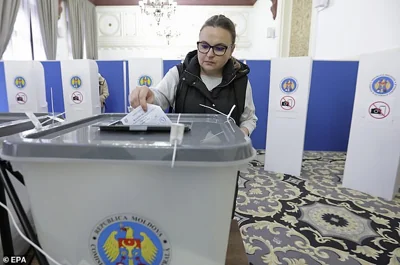 A Moldovan woman residing in Romania casts her ballot at a polling station during the second round of the presidential elections, in downtown Bucharest, Romania