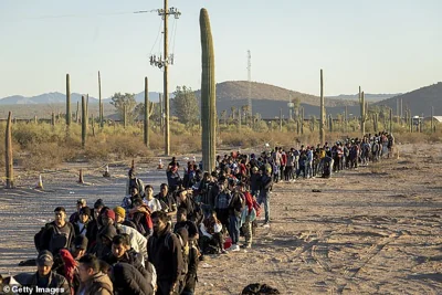 Immigrants line up at a remote U.S. Border Patrol processing center after crossing the U.S.-Mexico border