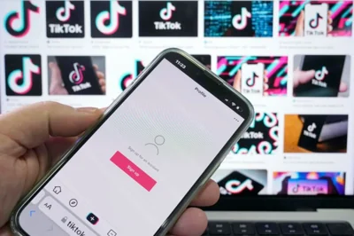 A sign up page for the application TikTok is shown on a cell phone in front of a screen with logos for the company in Sydney, Tuesday, April 4, 2023. Australia had become the last of the Five Eyes security partners to ban the Chinese-owned TikTok ap from government devices. (AP Photo/Rick Rycroft)