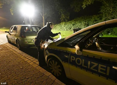 A police officer checks vehicles near the border with Belgium in Aachen on Monday