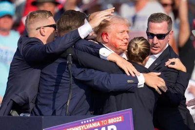 Republican presidential candidate former President Donald Trump is surrounded by U.S. Secret Service agents as he is helped off the stage at a campaign rally in Butler, Pa., July 13, 2024. Secret Service Director Kimberly Cheatle and the Secret Service are under intense scrutiny following the assassination attempt on Trump. (AP Photo/Gene J. Puskar, File)