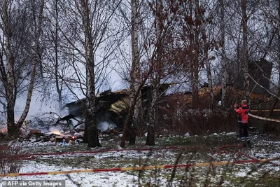 A Lithuanian medic takes a photo on his mobile phone of the wreckage of a cargo plane following its crash near the Vilnius International Airport in Vilnius on November 25, 2024