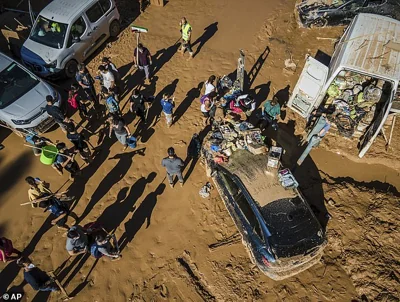 Volunteers and residents clean the mud four days after flash floods swept away everything in their path in Paiporta, outskirts of Valencia