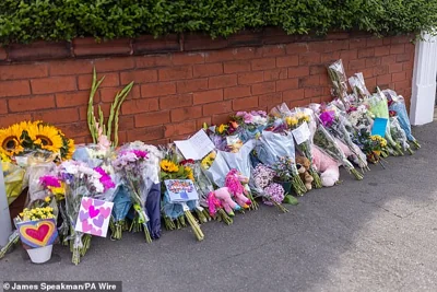 Floral tributes pile up by the side of the road as locals flock to share their sympathy after the tragedy
