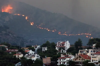 A fire approaches houses at Penteli mount, northeast Attica, Greece, 12 August 2024