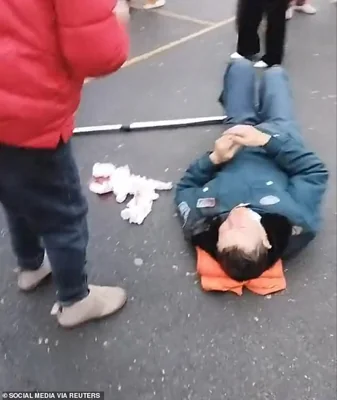 A person lies on the ground following a vehicle collision outside a primary school in Changde, Hunan province, China in this screengrab obtained from social media video released November 19, 2024