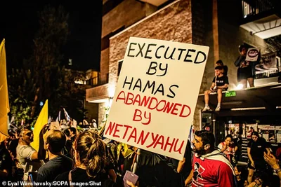 A protestor holds a placard during a protest in Tel Aviv on Monday