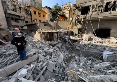 Residents observe the site of an Israeli airstrike that hit central Beirut, Lebanon, Saturday, Nov. 23, 2024. (AP Photo/Hussein Malla)