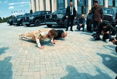 Рамзан Кадыров (слева) отжимается на камеру. Скриншот видео "Россия 1"