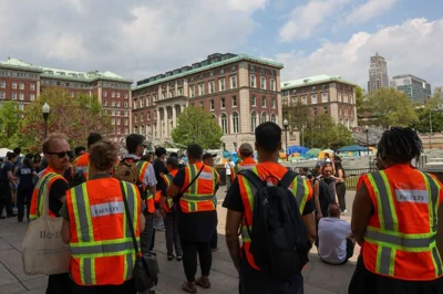 Faculty in orange vests arrive at the protests at Columbia University.
