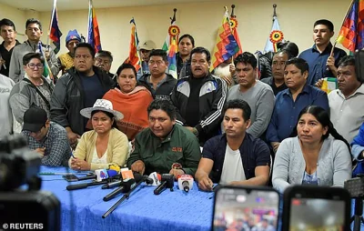 Supporters of Bolivia's former President Evo Morales address the media after Morales' assassination attempt claims