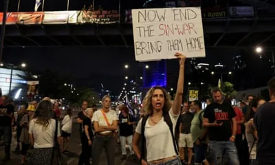 A demonstrator holds a sign in Israel demanding an end to the war in Gaza after the death of Yahya Sinwar