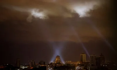 Ukrainian service personnel use searchlights as they search for drones in the sky over the city centre during a Russian drone strike on Kyiv.