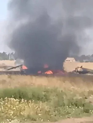A scene from video which appears to show the downed helicopter on fire
