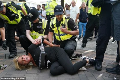 Police officers detain a woman during a protest in Nottingham Market Square this afternoon
