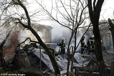 Rescuers work to extinguish a fire in a house following a drone attack in the village of Stanovoye, Moscow region, on November 10