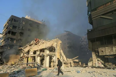 A man walks in front of a destroyed building at the site of an overnight Israeli airstrike that targeted Beirut's southern suburbs, Oct. 27. AFP-Yonhap 