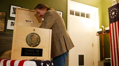 Dixville Notch, NH - January 23: Dixville Notch Town Moderator Tom Tillotson reaches into the ballot box to take out the first ballots cast in the New Hampshire Primary. Nikki Haley won Dixville Notch 6-0. (Photo by Jessica Rinaldi/The Boston Globe via Getty Images)