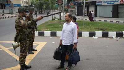 Солдат збройних сил Бангладеш просить пару повернутися до їхнього будинку в Даці під час загальнонаціональної комендантської години, Бангладеш, 20 липня 2024 року