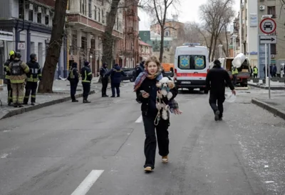 A woman with her dog walks at a site of apartment buildings hit by a Russian missile strike, amid Russia's attack on Ukraine, in Kharkiv, Ukraine November 25, 2024. REUTERS/Sofiia Gatilova TPX IMAGES OF THE DAY