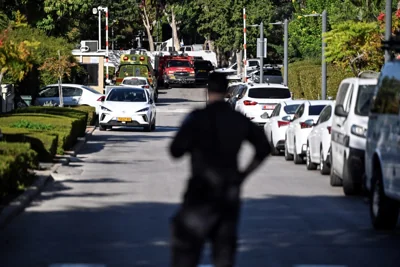 A member of Israeli security personnel stands at the entrance to a street, following a drone attack from Lebanon towards Israel