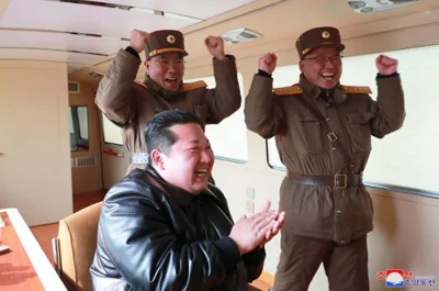 North Korean leader Kim Jong-un, front, celebrates after a Hwasong-17 intercontinental ballistic missile, or ICBM, was launched from Pyongyang International Airport in this photo released by North Korea's official Korean Central News Agency, March 24. Yonhap