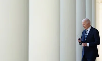 Joe Biden walks past white columns at the White House