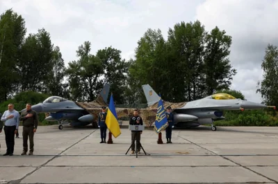 Ukraine's President Volodymyr Zelenskiy signs a national anthem next to F-16 fighting aircrafts during marking the Day of the Ukrainian Air Forces, amid Russia's attack on Ukraine, in an undisclosed location, Ukraine August 4, 2024. REUTERS/Valentyn Ogirenko